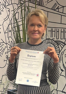 Beate Reinhart präsentiert stolz ihr Diplom als Wertorientierter systemischer Business Coach (CAS/ISO/ICI), erworben an der Coach Akademie Schweiz, mit Fokus auf Business Coaching und Führungskräfteentwicklung.