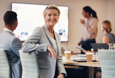 Weibliche Führungskraft nimmt an einem interaktiven Workshop zum Thema "Konfliktkompetenz trainieren" teil und hat Spaß dabei.