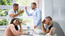 Im Bild zu sehen sind zwei Mitarbeiter, die im Team offen miteinander einen Konflikt austragen. Ein typisches Einsatzgebiet für eine Mediation am Arbeitsplatz in Nürnberg.