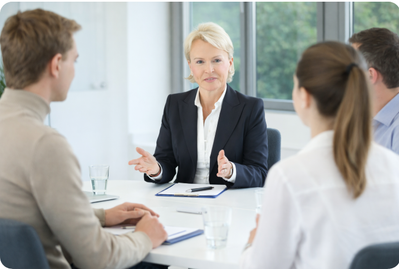Mediation im Unternehmen: Die Mediatorin Beate Reinhart moderiert ein strukturiertes Gespräch zur Konfliktklärung mit Führungskräften und Teammitgliedern im Meetingraum.